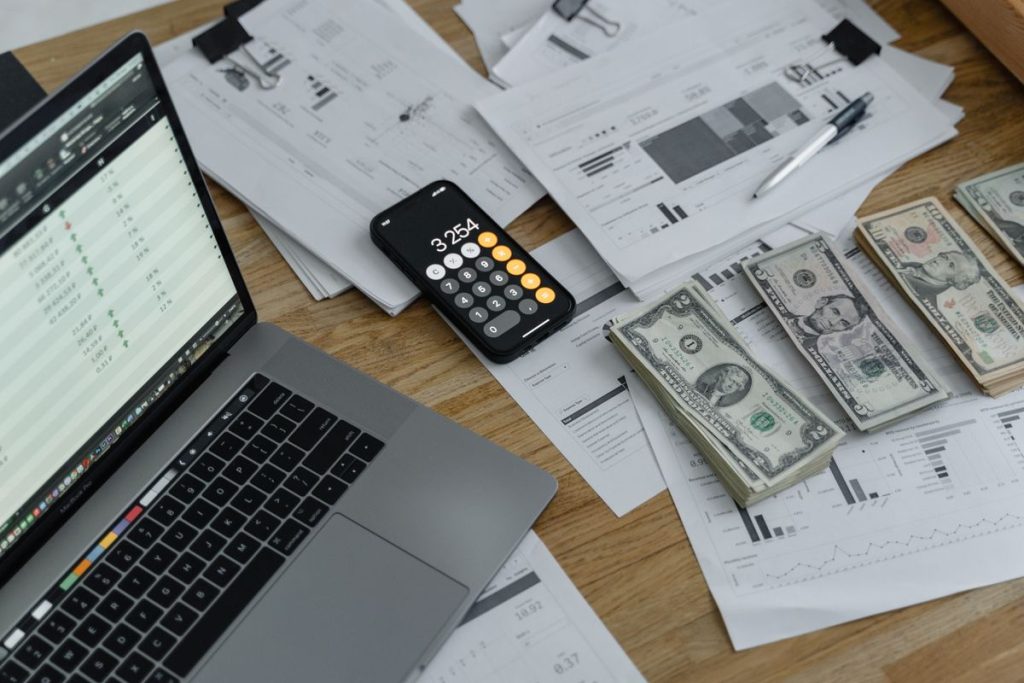 Laptop, calculator and banknotes on a desk — selling Spanish property from abroad
